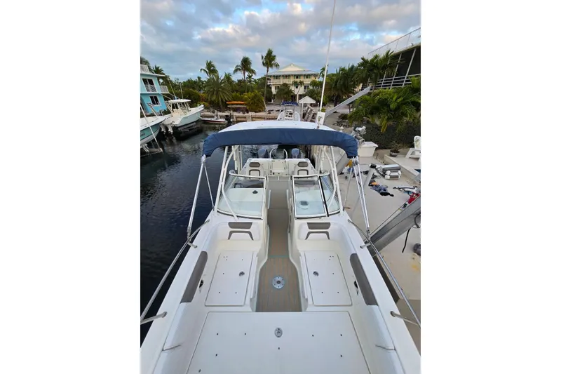 Slide: The Image of 2019 World Cat 255 DC boat docked, featuring spacious deck and canopy. - 5