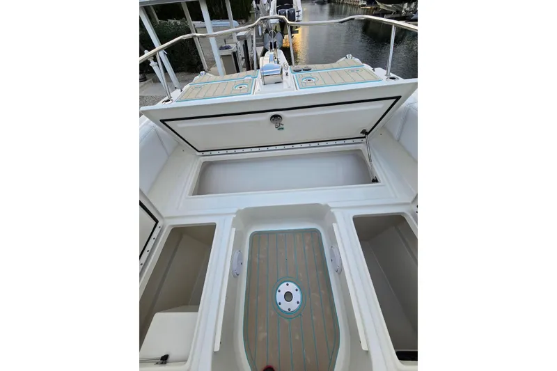 Slide: The Image of 2019 World Cat 255 DC boat interior with open storage compartments and deck view. - 6