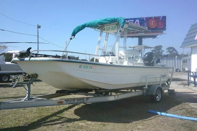 Slide: The Image of 2005 Sundance B22CX boat on trailer with green canopy, parked outdoors. - 10