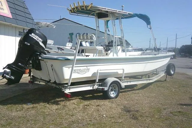 Slide: The Image of 2005 Sundance B22CX boat on trailer with Suzuki outboard motor, parked outdoors. - 5