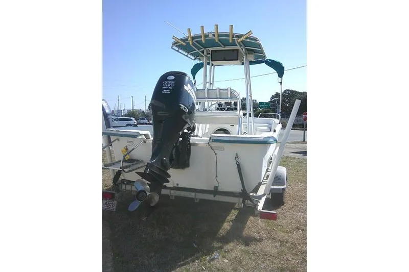 Slide: The Image of 2005 Sundance B22CX boat with outboard motor on trailer, parked outdoors. - 6