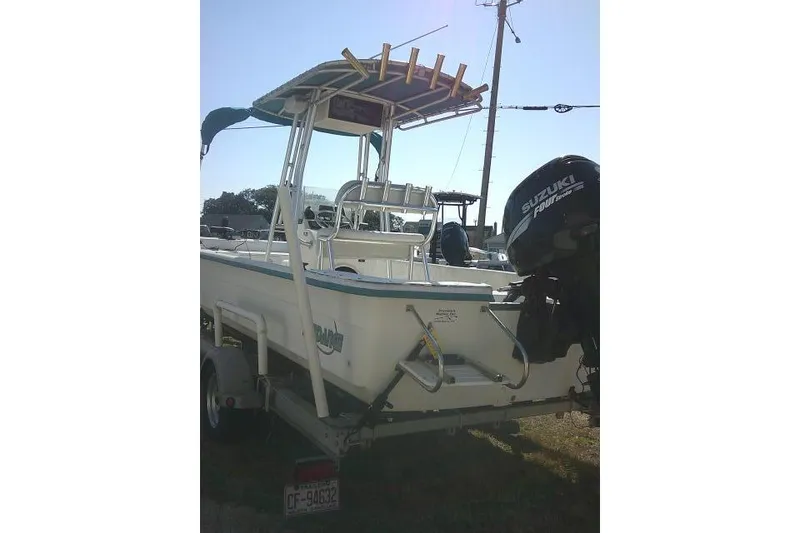 Slide: The Image of 2005 Sundance B22CX boat with Suzuki outboard motor, parked on a trailer. - 8