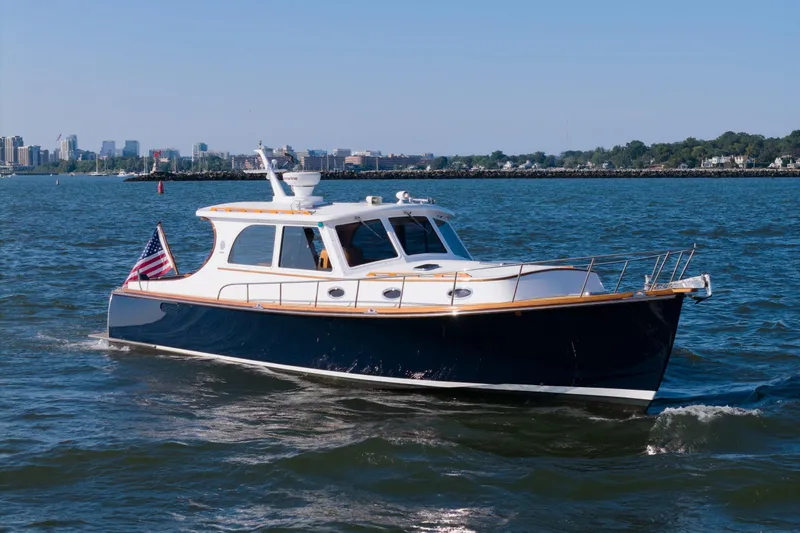 The Image of 2007 Gorbon Custom Downeast 40 yacht cruising on open water with city skyline backdrop. - 0