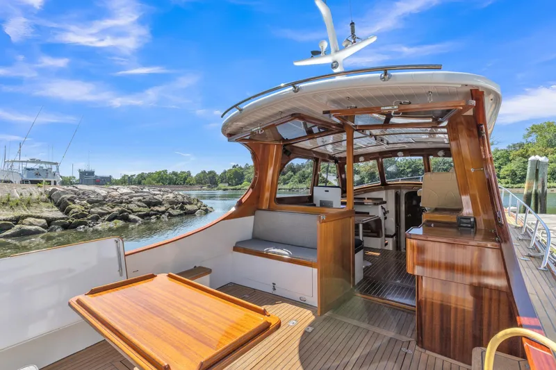 Slide: The Image of 2007 Gorbon Custom Downeast 40 yacht interior with wooden finishes, docked by rocky shoreline. - 12