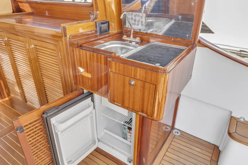 Slide: The Image of Luxurious 2007 Gorbon Custom Downeast 40 yacht interior with wooden cabinetry and compact kitchen amenities. - 13