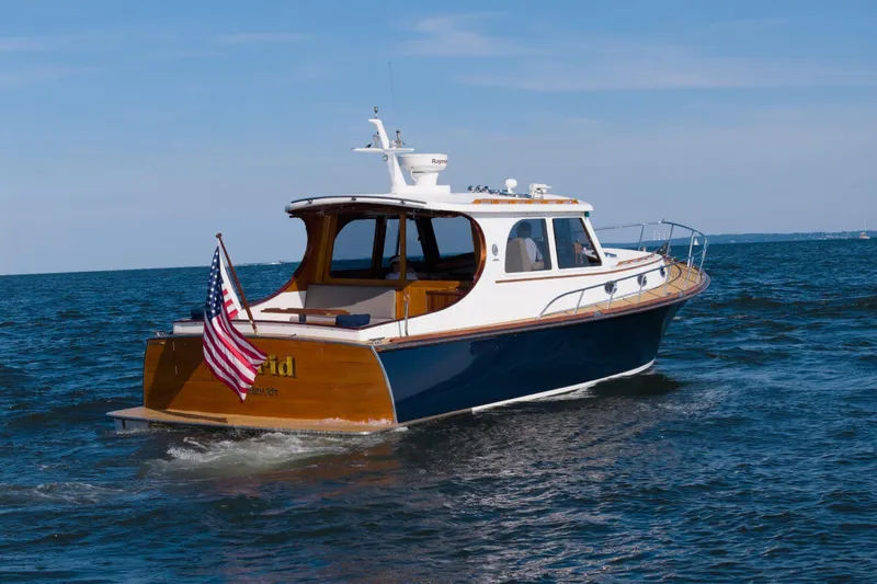 Slide: The Image of 2007 Gorbon Custom Downeast 40 yacht cruising on open water, displaying American flag. - 3