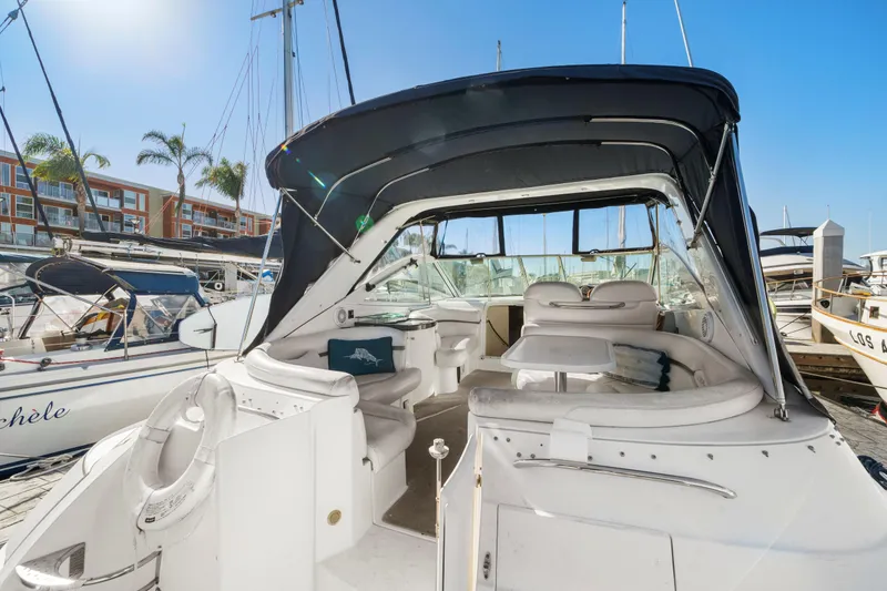 Slide: The Image of 2005 Doral 360se yacht interior at marina, featuring seating and table under canopy. - 28