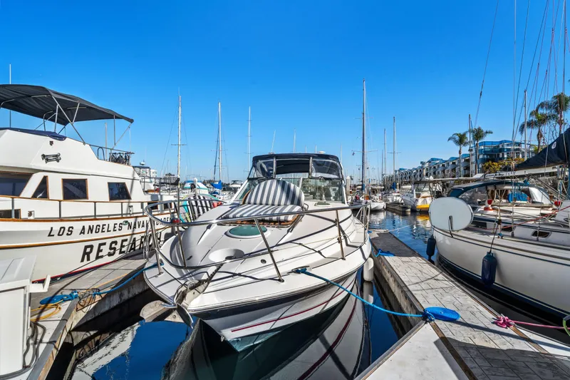 Slide: The Image of 2005 Doral 360se boat docked in a sunny marina, surrounded by other vessels. - 3