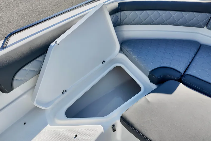Slide: The Image of 2026 NauticStar 231 Hybrid boat interior with open storage compartment and cushioned seating. - 14