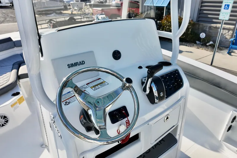 Slide: The Image of 2026 NauticStar 231 Hybrid boat helm with Simrad electronics and steering wheel. - 18
