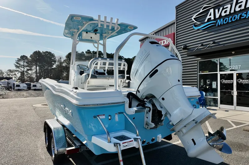 Slide: The Image of 2026 NauticStar 231 Hybrid boat with outboard motor at dealership. - 20