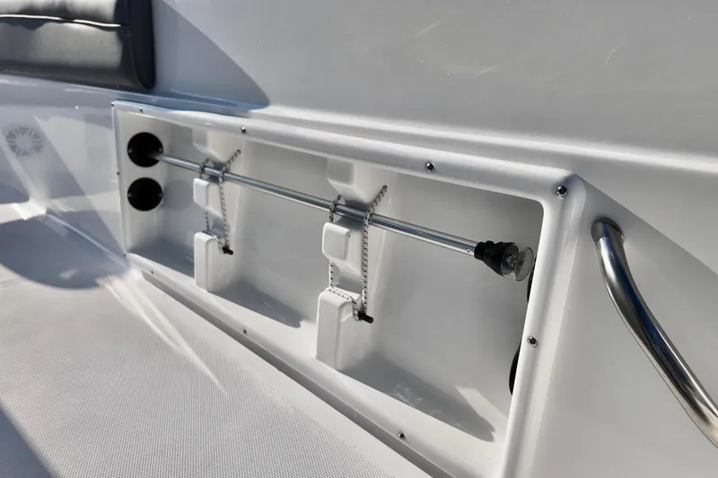 Slide: The Image of 2026 NauticStar 231 Hybrid boat interior detail with rod holders and stainless steel railing. - 8
