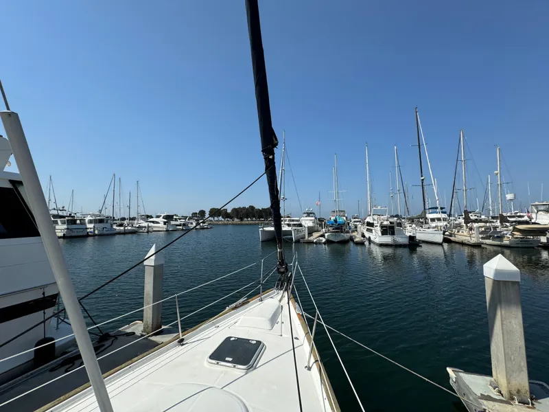 Slide: The Image of Beneteau Oceanis Clipper 473 sailboat docked in a marina, surrounded by other boats. - 10