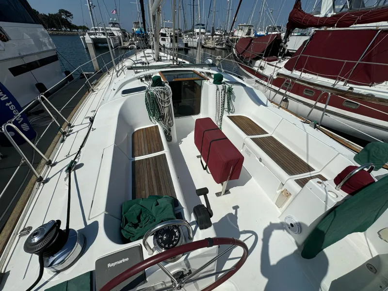 Slide: The Image of 2001 Beneteau Oceanis Clipper 473 sailboat cockpit with wooden seating and marina view. - 6