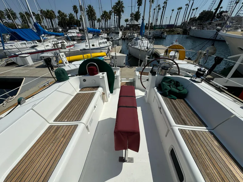 Slide: The Image of Beneteau Oceanis Clipper 473 sailboat cockpit, 2001 model, docked in a marina with palm trees. - 7