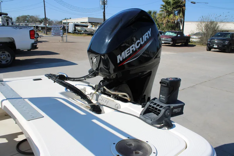 Slide: The Image of 2022 Mako Pro Skiff 15 CC with Mercury outboard motor in a parking lot. - 4