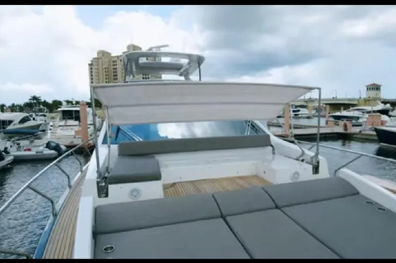 Slide: The Image of 2017 Azimut 66 yacht docked at marina, featuring spacious deck and seating area. - 25