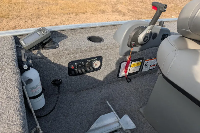 Slide: The Image of 2017 Tracker Panfish 16 boat interior with control panel and fire extinguisher. - 22