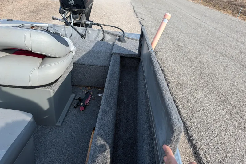 Slide: The Image of 2017 Tracker Panfish 16 boat interior with storage compartment open, showing seating and equipment. - 23