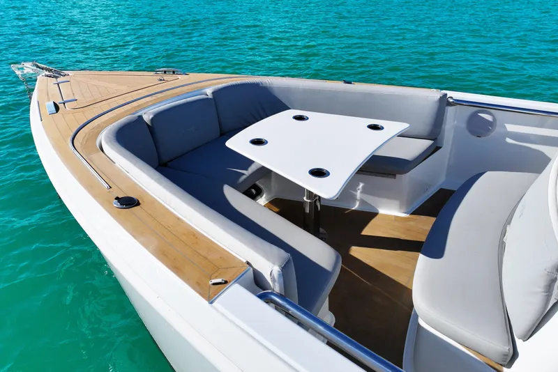 Slide: The Image of 2018 Fjord 36 Xpress boat with sleek seating and table on turquoise water. - 12