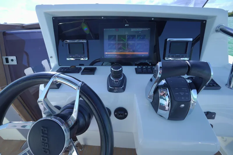Slide: The Image of Control panel of 2018 Fjord 36 Xpress boat with steering wheel and navigation screens. - 19