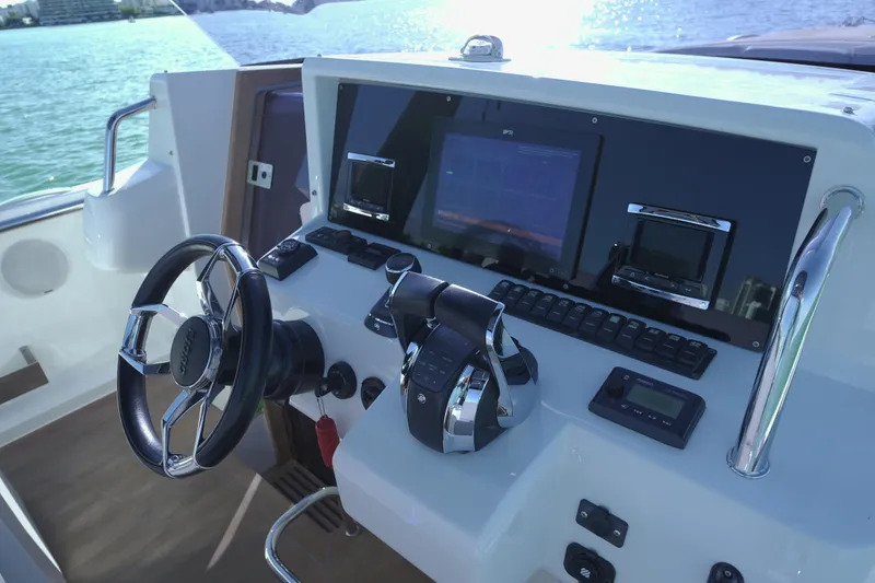 Slide: The Image of Control panel of a 2018 Fjord 36 Xpress boat with steering wheel and navigation screens. - 20
