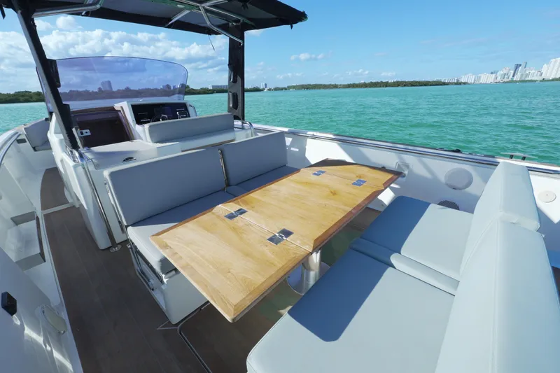 Slide: The Image of 2018 Fjord 36 Xpress boat interior with seating and wooden table on open water. - 31