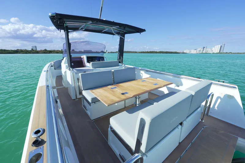 Slide: The Image of 2018 Fjord 36 Xpress boat with spacious seating, cruising on turquoise waters near a city skyline. - 32