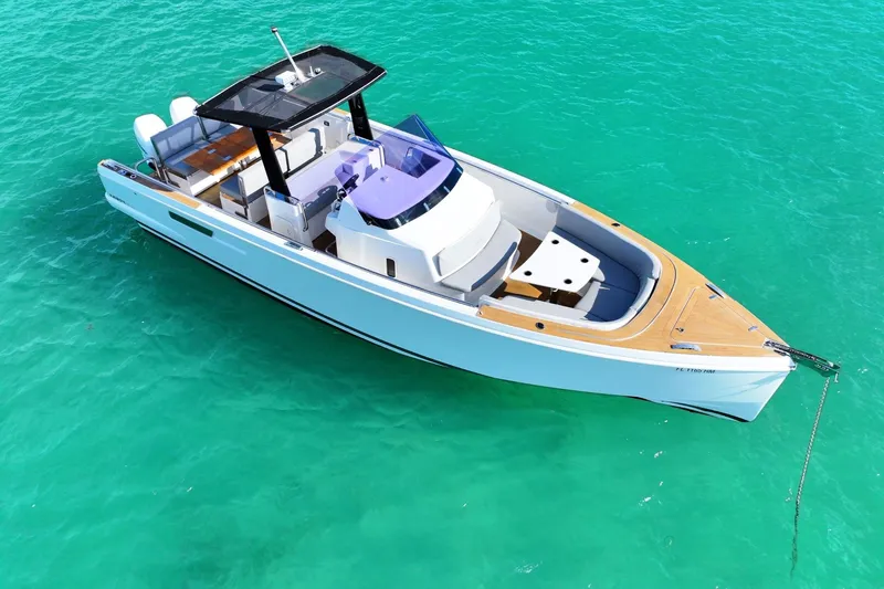 Slide: The Image of 2018 Fjord 36 Xpress boat on turquoise water, featuring sleek design and spacious deck. - 9