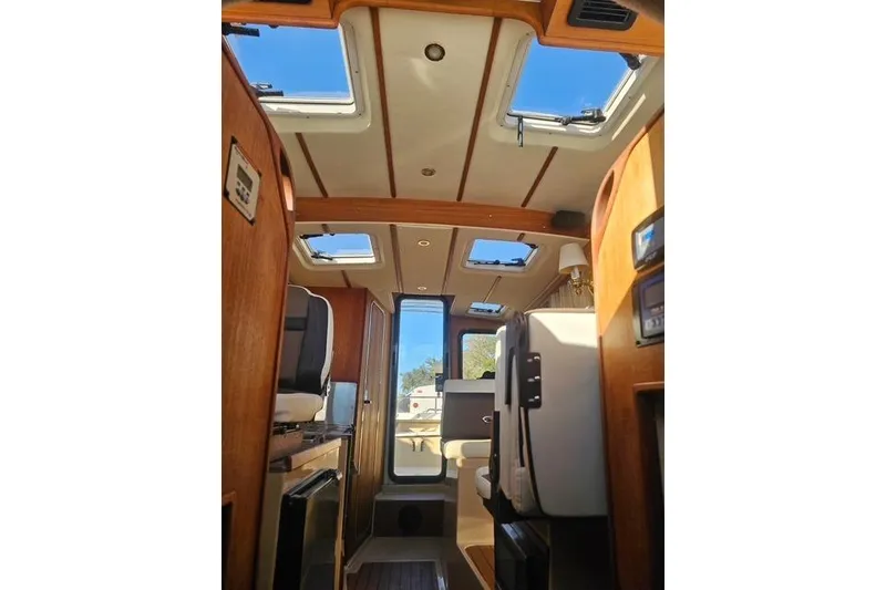 Slide: The Image of Interior of 2017 Ranger Tugs R-27 boat, featuring skylights and wooden finishes. - 17