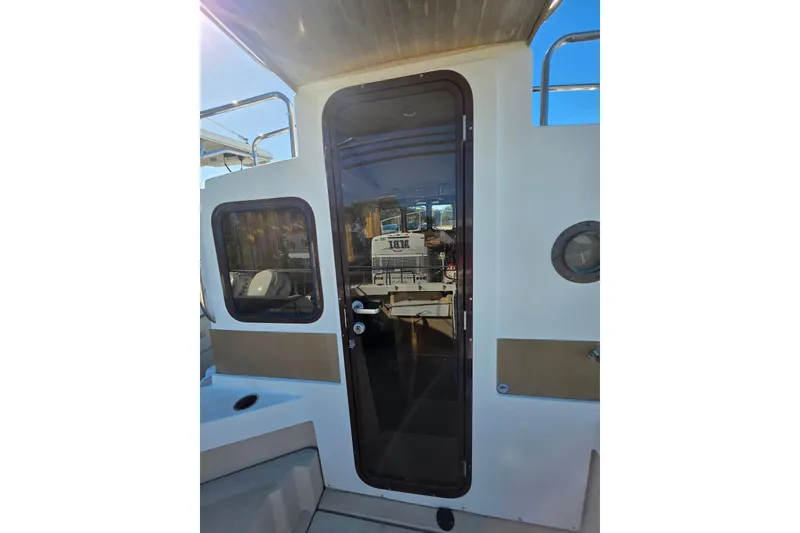 Slide: The Image of 2017 Ranger Tugs R-27 boat exterior with door and windows, showcasing sleek design. - 19