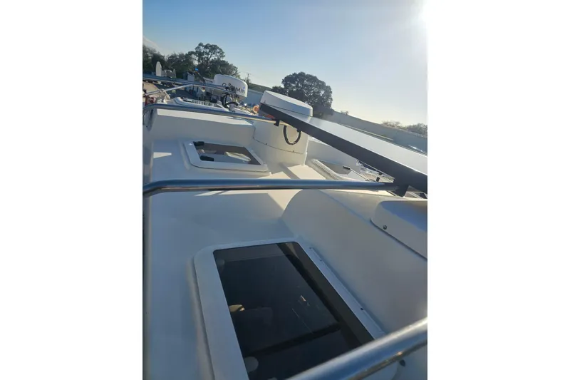 Slide: The Image of 2017 Ranger Tugs R-27 boat deck with hatches and railings under clear sky. - 4