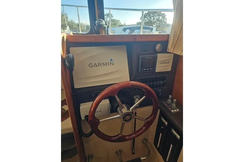 Slide: The Image of 2017 Ranger Tugs R-27 helm with Garmin navigation system and wooden steering wheel. - 8