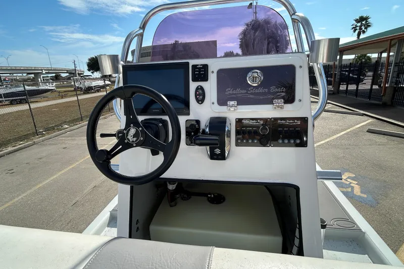 Slide: The Image of 2023 Shallow Stalker Cat 240 Elite boat console with steering wheel and controls. - 12