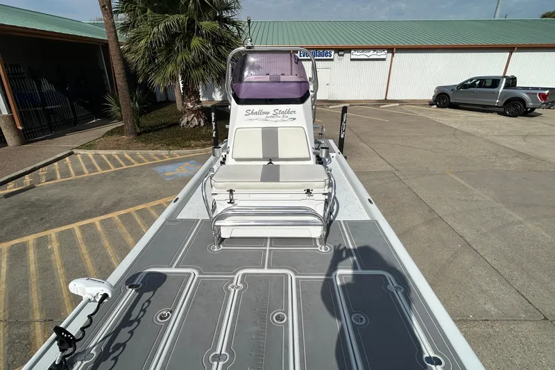Slide: The Image of 2023 Shallow Stalker Cat 240 Elite boat in parking lot, showcasing sleek design and seating. - 17