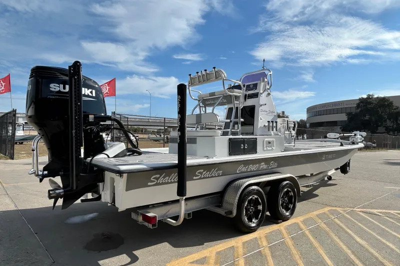 Slide: The Image of 2023 Shallow Stalker Cat 240 Elite boat with Suzuki engine on trailer, outdoor setting. - 6