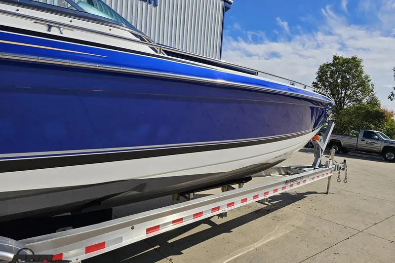 Slide: The Image of 2009 Formula 353 FASTech boat on trailer, blue and white hull, outdoor setting. - 13