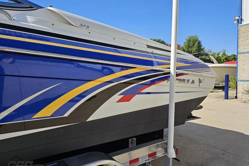 Slide: The Image of 2009 Formula 353 FASTech boat with vibrant blue, yellow, and red graphics on trailer. - 26