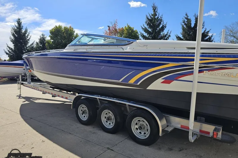 Slide: The Image of 2009 Formula 353 FASTech boat on trailer, vibrant graphics, parked outdoors. - 28