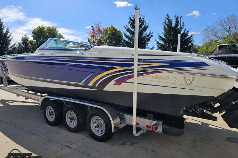 Slide: The Image of 2009 Formula 353 FASTech boat on trailer, vibrant graphics, sunny day, trees in background. - 29