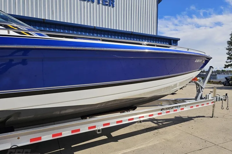 Slide: The Image of 2009 Formula 353 FASTech boat on trailer, blue and white hull, parked outside. - 5