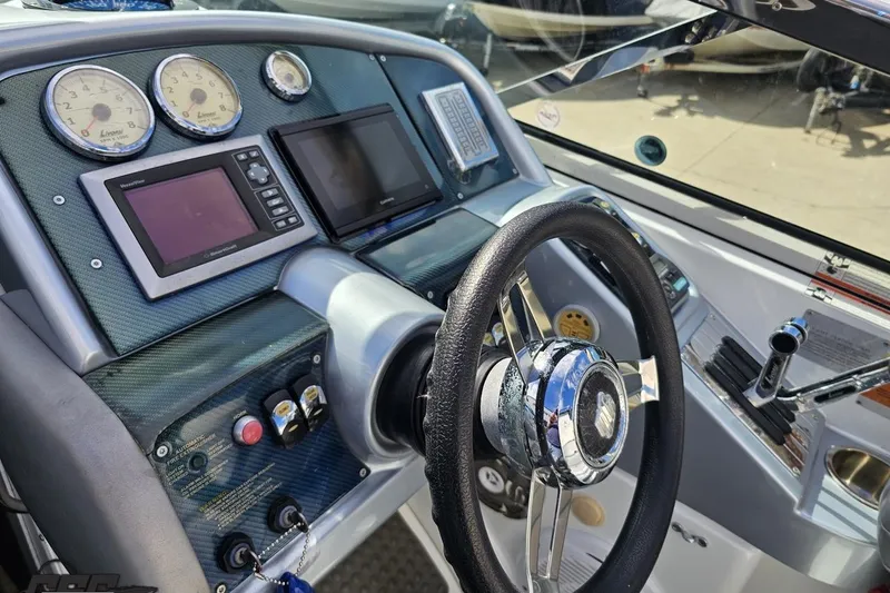 Slide: The Image of 2009 Formula 353 FASTech boat dashboard with steering wheel and navigation instruments. - 62