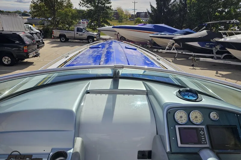 Slide: The Image of 2009 Formula 353 FASTech boat dashboard with blue cover, parked among other boats. - 70