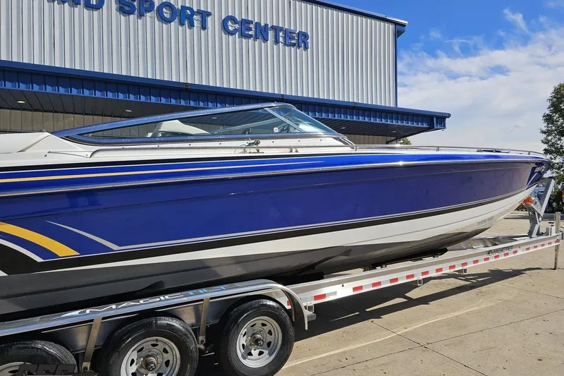 Slide: The Image of 2009 Formula 353 FASTech boat on trailer at sport center, blue and white design. - 9