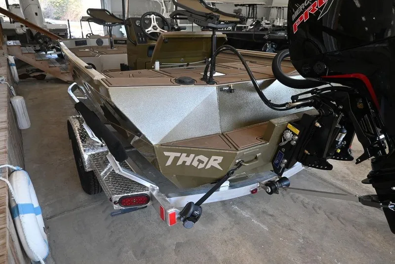 Slide: The Image of 2026 Thor 1900 boat on trailer with powerful outboard motor in a garage setting. - 1