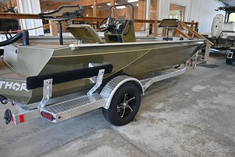 Slide: The Image of 2026 Thor 1900 boat on trailer in showroom, featuring sleek design and modern equipment. - 4