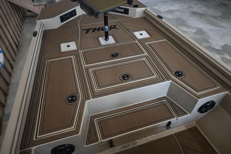 Slide: The Image of 2026 Thor 1900 boat deck with brown paneling and storage compartments. - 8
