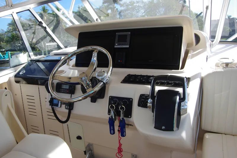 Slide: The Image of Helm of 2010 Grady-White Express 330 boat with steering wheel and controls. - 13