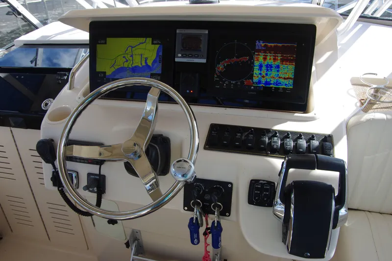 Slide: The Image of 2010 Grady-White Express 330 helm with navigation screens and steering wheel. - 14