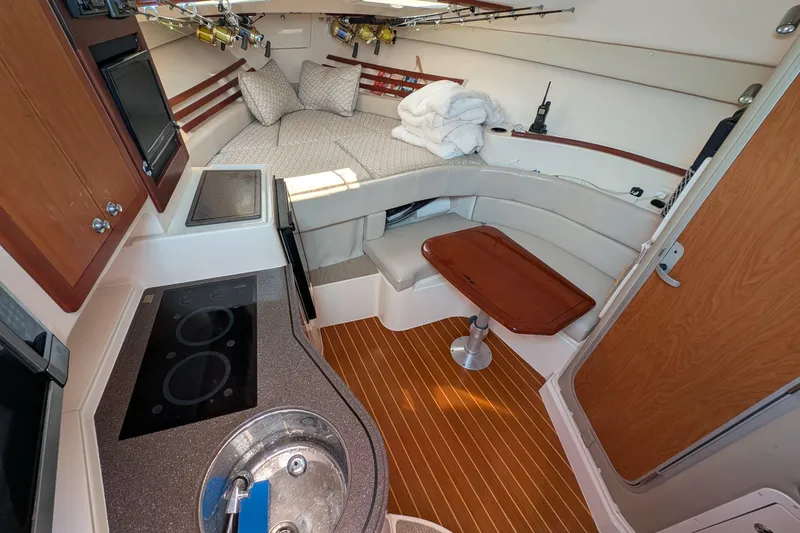 Slide: The Image of Interior of 2010 Grady-White Express 330 boat with kitchenette and cozy seating area. - 23